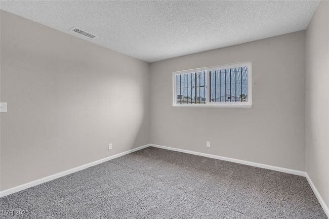 Carpeted empty room with baseboards, a textured ceiling, and visible vents | Image 20