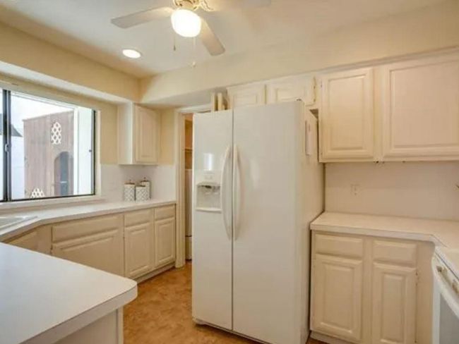 Kitchen featuring white fridge with ice dispenser, ceiling fan, light countertops, a sink, and recessed lighting | Image 10