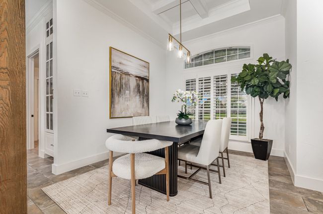 Dining space with crown molding, beam ceiling, coffered ceiling, and a towering ceiling | Image 8