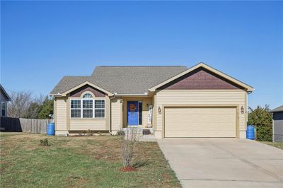 Single story home with a front lawn and a garage | Image 1