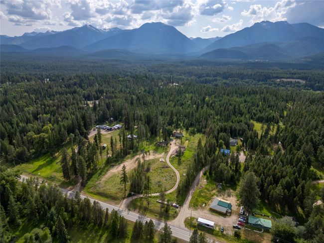 Aerial view of property and surrounding area featuring a heavily wooded area and mountains | Image 26
