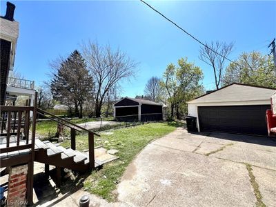 View of yard featuring an outdoor structure and a garage | Image 3