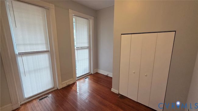 Unfurnished bedroom featuring dark wood-type flooring and baseboards | Image 5