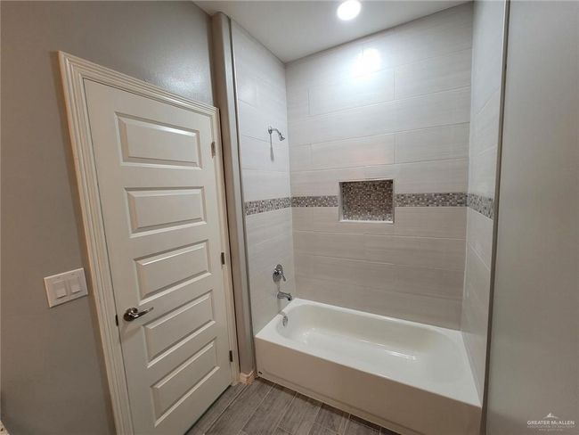 Bathroom featuring wood finished floors and shower / bath combination | Image 8