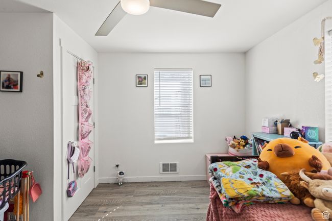 Bedroom with wood finished floors, a ceiling fan, and baseboards | Image 11