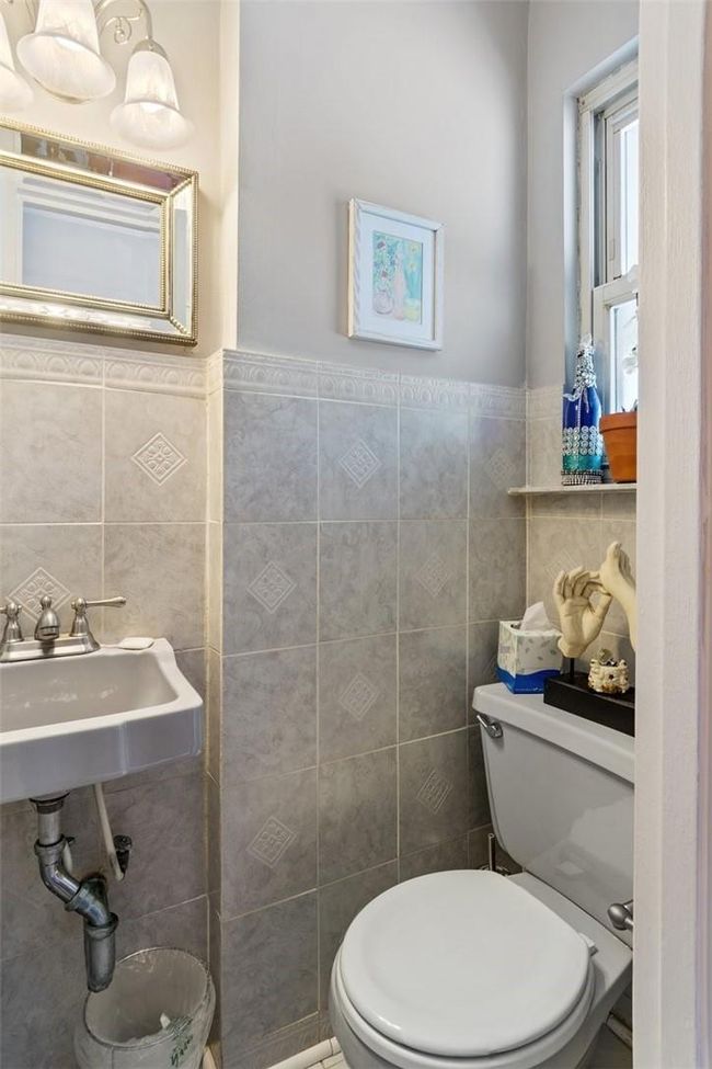 Bathroom featuring tile walls, toilet, and sink | Image 21