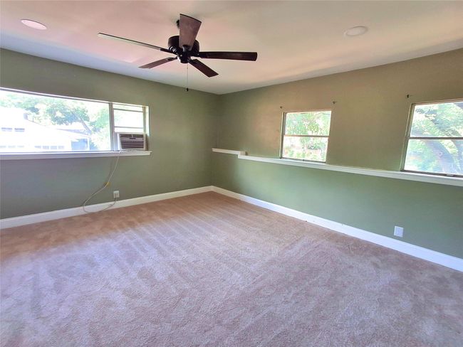 Unfurnished room with healthy amount of natural light, baseboards, ceiling fan, and carpet flooring | Image 25
