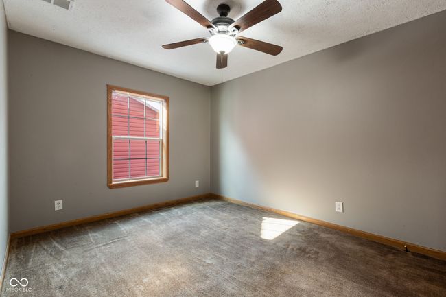 empty room with a textured ceiling, baseboards, a ceiling fan, and carpet | Image 31
