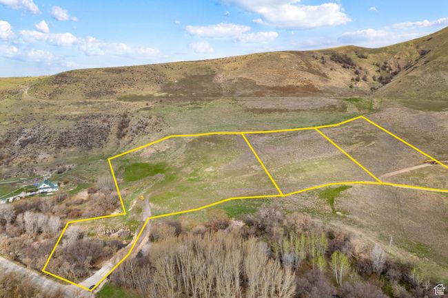 Aerial view of property and surrounding area featuring a mountainous background and property parcel outlined | Image 19