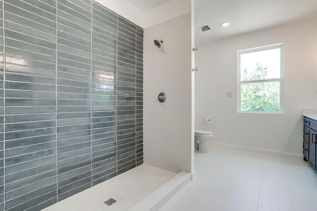 Full bath featuring a tile shower, vanity, recessed lighting, toilet, and tile patterned floors | Image 19