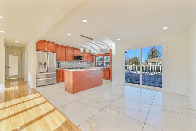 Kitchen featuring crown molding, stainless steel appliances, a center island, decorative backsplash, and decorative light fixtures | Image 19