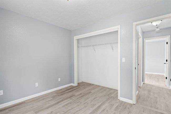 Unfurnished bedroom featuring visible vents, ceiling fan, a closet, baseboards, and wood finished floors | Image 13