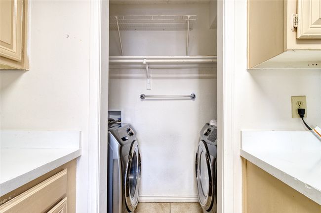 Laundry area featuring washing machine and clothes dryer and light tile patterned floors | Image 16