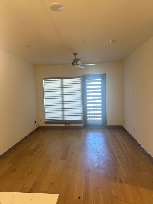 Empty room featuring a ceiling fan and light wood finished floors | Image 9
