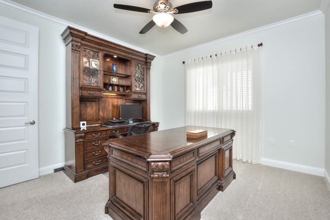 Office featuring crown molding, a ceiling fan, baseboards, and light carpet | Image 19