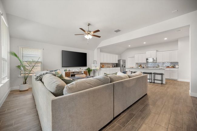Living room featuring lofted ceiling, ceiling fan, light wood-style flooring, and recessed lighting | Image 11