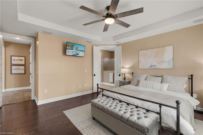 Bedroom featuring a tray ceiling, ceiling fan, and dark wood-type flooring | Image 17