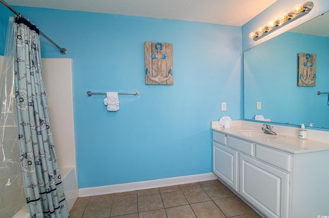 Full bath featuring tile patterned flooring, vanity, shower / tub combo, and baseboards | Image 37