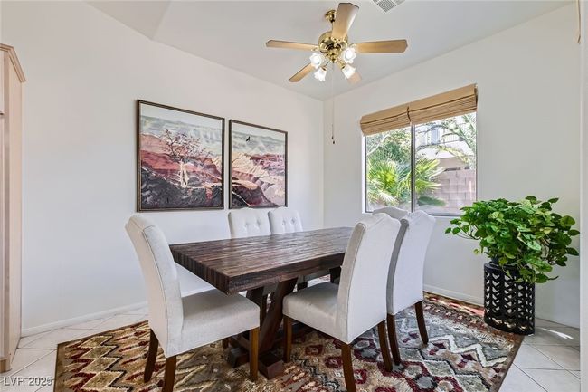 Dining space with light tile patterned floors, ceiling fan, and baseboards | Image 13