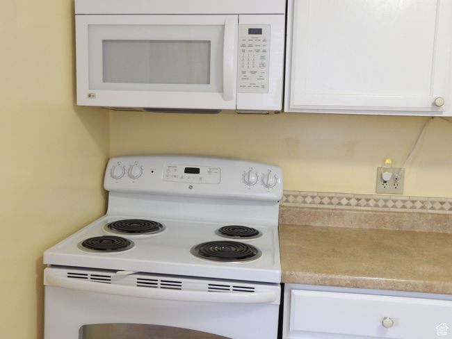 Kitchen with white cabinets and white appliances | Image 19
