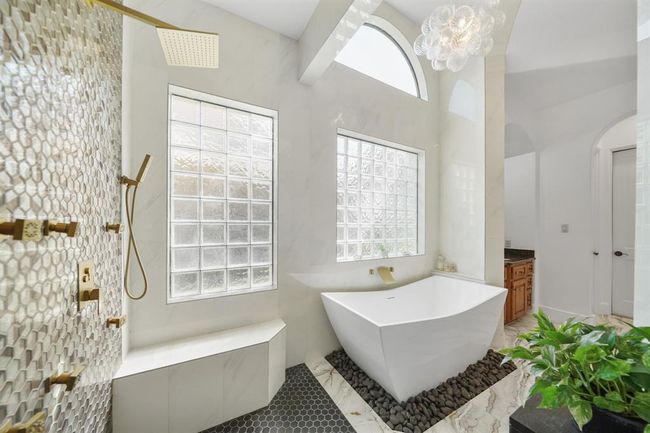 Gorgeous! Located nearby is a free-standing tub with wall mounted plumbing fixtures accompanied by glass block privacy windows. | Image 24