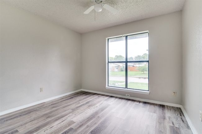 Unfurnished room with light wood-style floors, a textured ceiling, and a ceiling fan | Image 14
