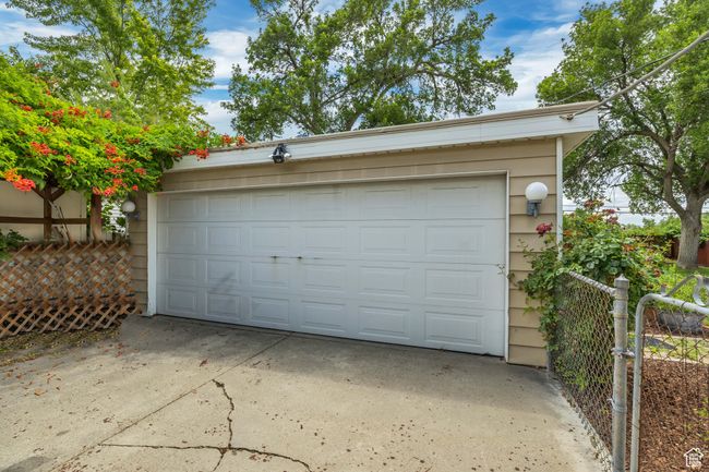 Garage with driveway and a gate, large storage closet at the back. New roof on top! | Image 16