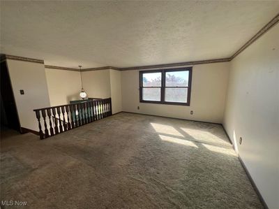 Carpeted spare room featuring ornamental molding and a textured ceiling | Image 3