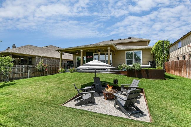 Rear view of house featuring a fire pit, a patio area, and a ceiling fan | Image 31