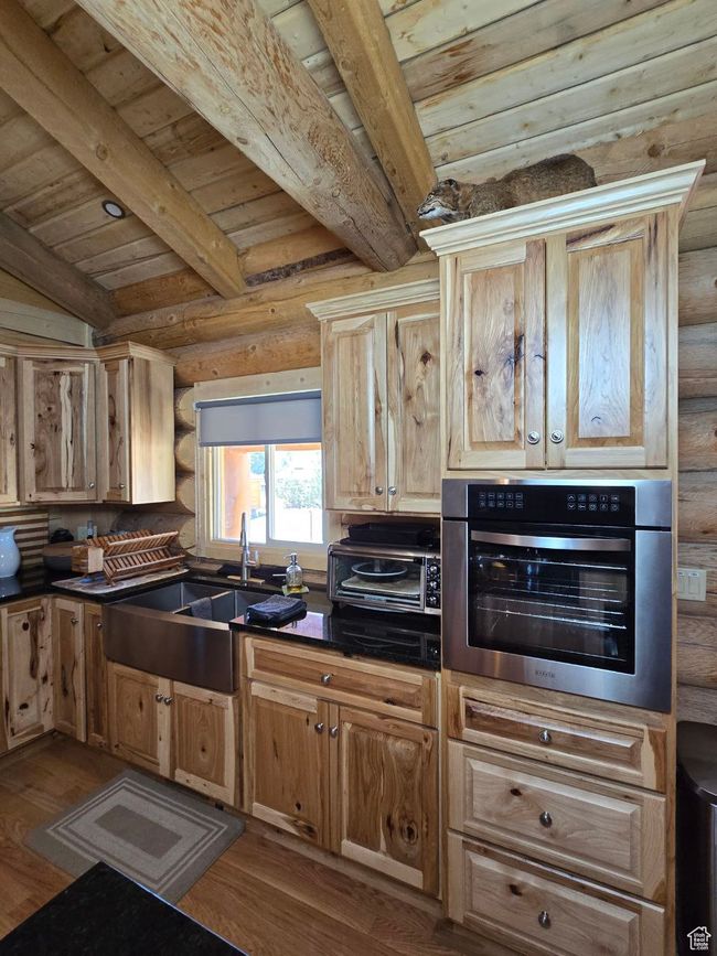 Kitchen featuring oven, dark countertops, wood finished floors, and a sink | Image 58