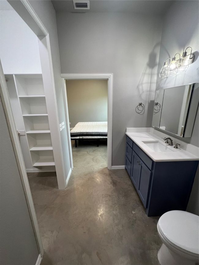 Bathroom features granite countertops with vanity, toilet, and concrete flooring | Image 29
