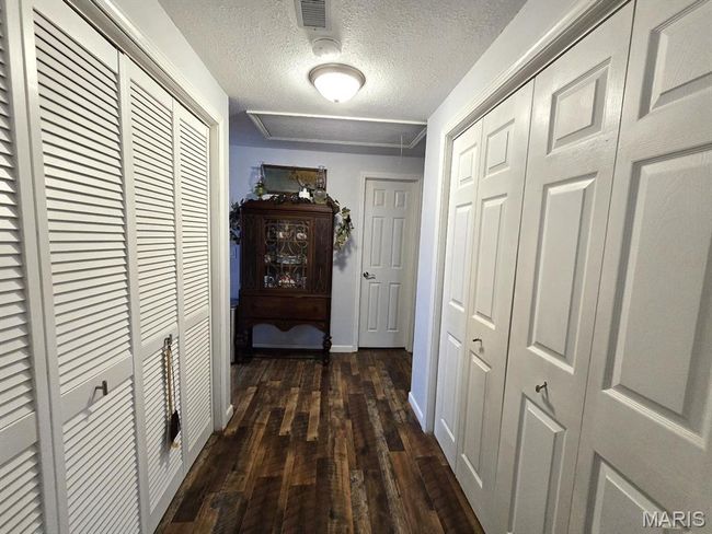 Hall with dark wood-style flooring and a textured ceiling | Image 17
