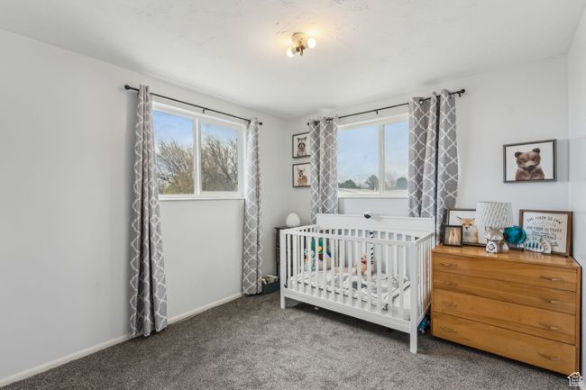 Carpeted bedroom with a crib and baseboards | Image 12