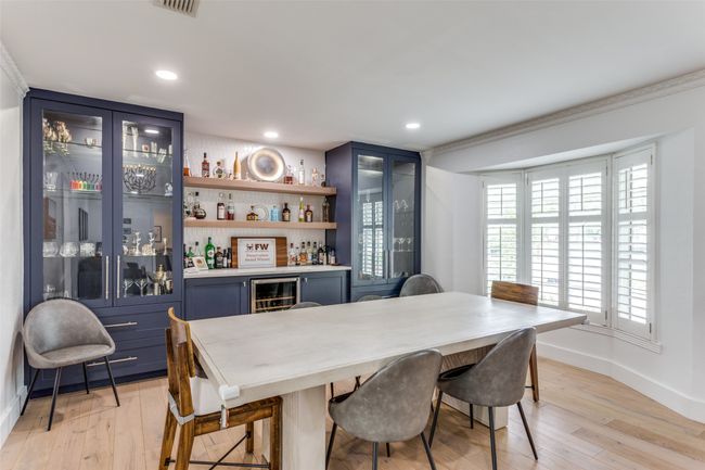 Dining room with built-in cabinetry, quartz serving bar, wine refrigerator and bay window. | Image 5