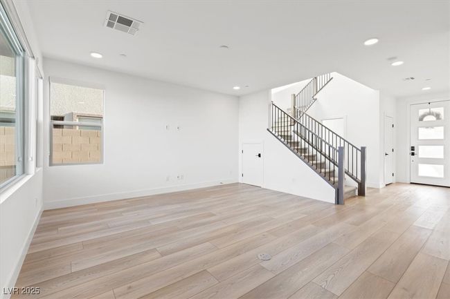 Unfurnished living room with baseboards, stairway, light wood-style flooring, and recessed lighting | Image 23