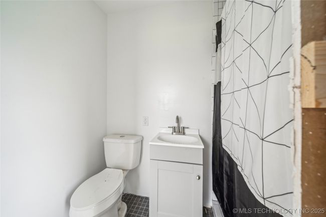 Bathroom featuring tile patterned flooring, toilet, vanity, and a shower with shower curtain | Image 30