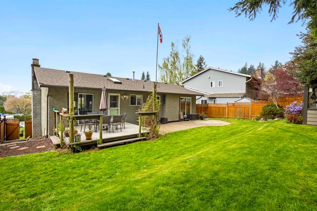 Rear view of house featuring a shingled roof, a lawn, a chimney, fence, and stucco siding | Image 25