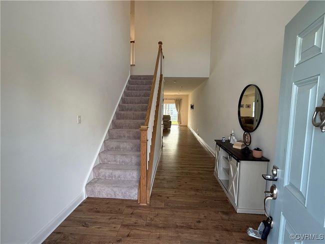 Foyer entrance with dark wood-style floors, stairs, baseboards, and a high ceiling | Image 30