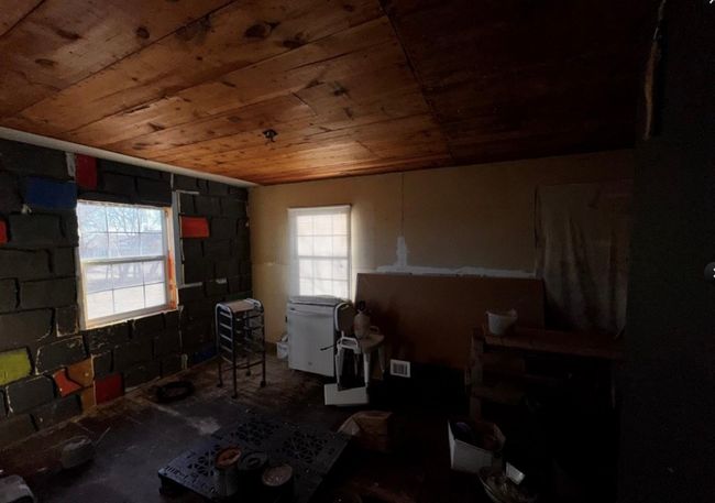 Misc room featuring wood ceiling and concrete block wall | Image 12