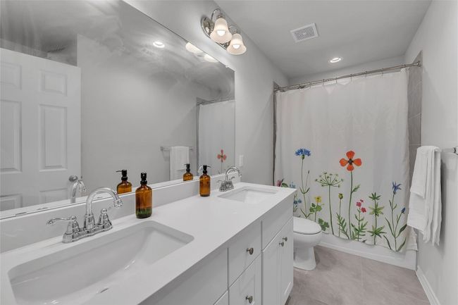 Bathroom featuring double vanity, toilet, tile patterned floors, baseboards, and recessed lighting | Image 21