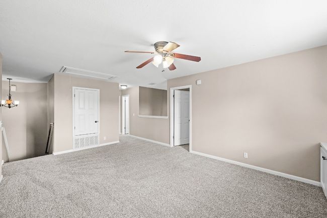 Carpeted empty room with attic access and a ceiling fan | Image 10