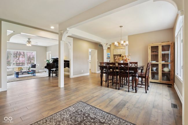 dining room with baseboards, visible vents, ceiling fan with notable chandelier, and hardwood / wood-style flooring | Image 8