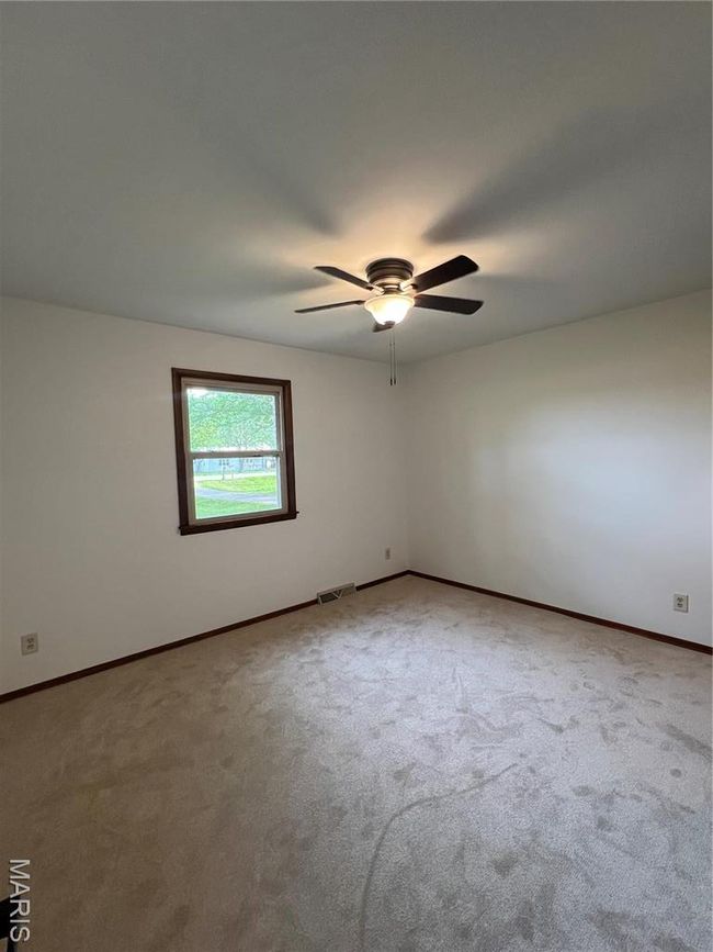 Carpeted spare room with visible vents, baseboards, and a ceiling fan | Image 7