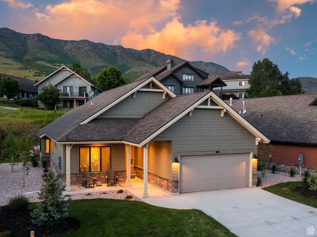 Craftsman house with stone siding, a garage, a mountain view, a porch, and concrete driveway | Image 29