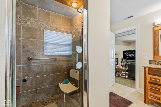 bathroom with visible vents, tile patterned floors, a shower stall, and vanity | Image 28