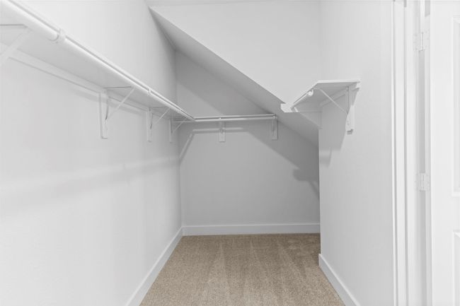 Spacious walk-in closet located within the primary suite offers built-in shelving and ample hanging space for effortless organization. **Image Representative of Plan Only and May Vary as Built**. | Image 20