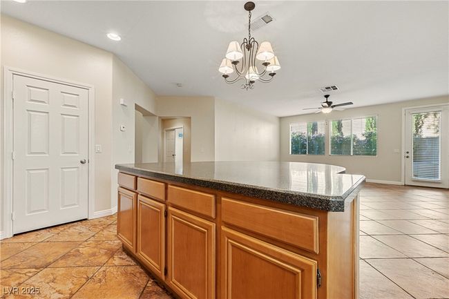 Kitchen featuring a center island, a chandelier, pendant lighting, ceiling fan, and recessed lighting | Image 20