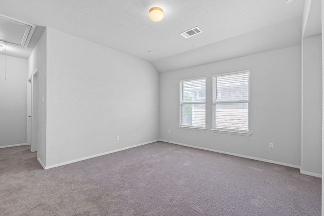 Carpeted empty room featuring attic access and vaulted ceiling | Image 17