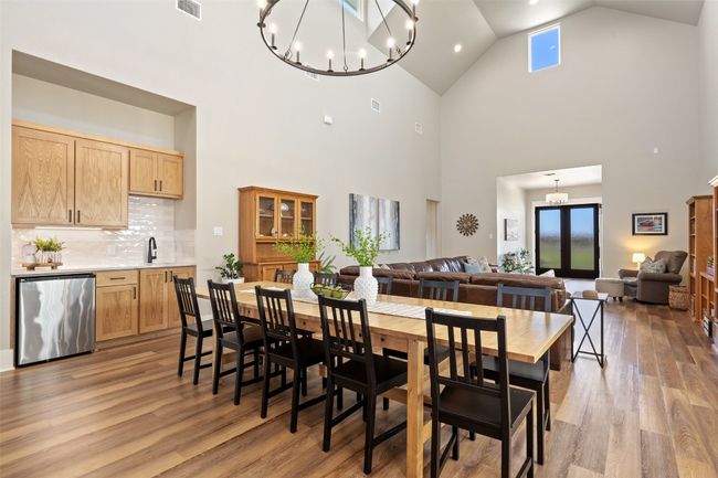 Dining room with a chandelier, high vaulted ceiling, and light wood finished floors | Image 7