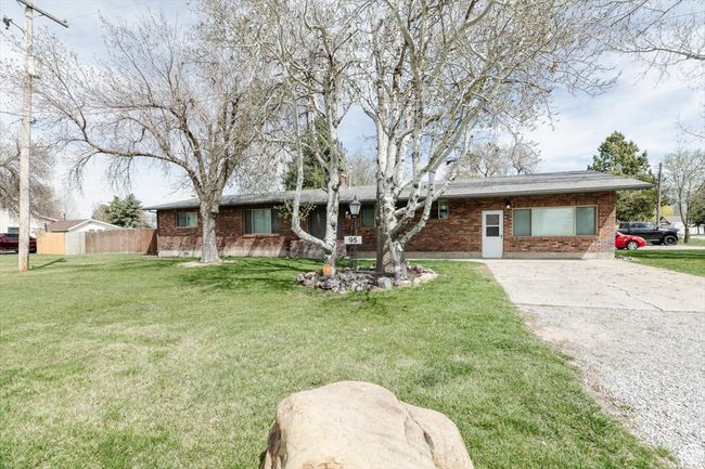 Ranch-style house with concrete driveway, fence, a front lawn, and brick siding | Image 45